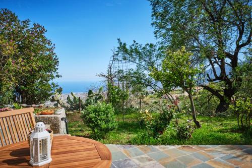 a wooden table on a patio with a view of a garden at Tizziri rural in Santa Cruz de Tenerife