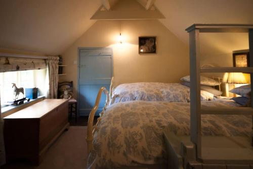 a bedroom with a bed with a dresser and a sink at Cissys Cottage in a Nature Reserve, 7 minutes from Aldeburgh seafront 