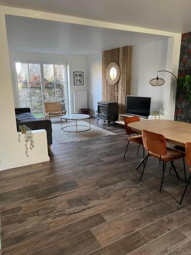 a living room with wooden floors and a table and chairs at Gîtes des Remparts in Philippeville