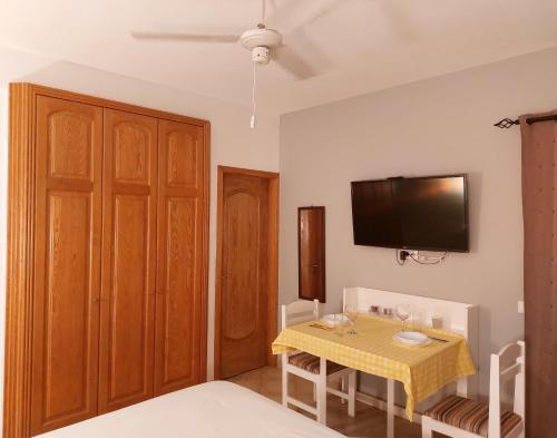 a dining room with a table and a tv on the wall at Apartamento Antunes in Santa Maria