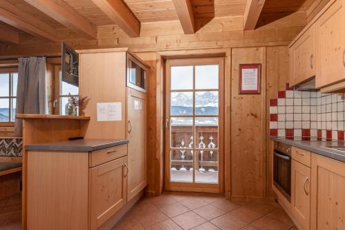 a kitchen with wooden walls and a large window at Almwelt Austria in Schladming