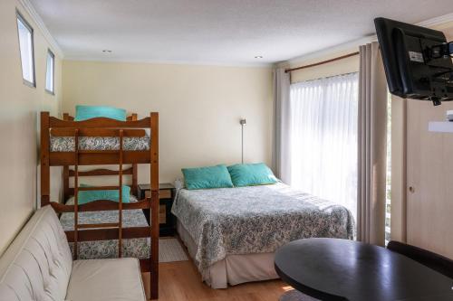 a bedroom with a bed and a bunk bed at Apart Hotel Colors in La Serena