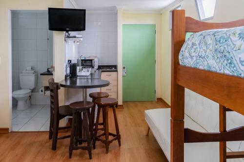 a bedroom with a bunk bed and a table and chairs at Apart Hotel Colors in La Serena