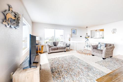 a living room with a flat screen tv and two chairs at Tidal Links - 4 Bed 3 Bath Vacation home in Bandon Dunes in Bandon
