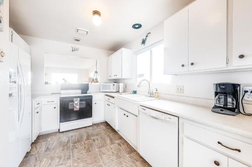 a white kitchen with white cabinets and appliances at Tidal Links - 4 Bed 3 Bath Vacation home in Bandon Dunes in Bandon