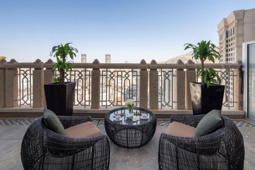 een patio met stoelen en tafels op een balkon bij Raffles Makkah Palace in Mekka
