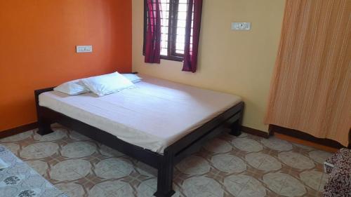 VILLA UMAR HOMESTAY في بونديتْشيري: سرير صغير في غرفة مع نافذة