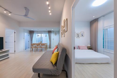 a bedroom with a bed and a living room at Ther house Banchang in Ban Chang