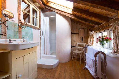 a bathroom with a sink and a toilet and a tub at Orchard Cottage cosy rustic comfort just across the fields to a great Pub 