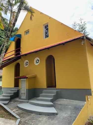 a yellow building with stairs in front of it at Hotel Fazenda Bonanza in Engenheiro Paulo de Frontin