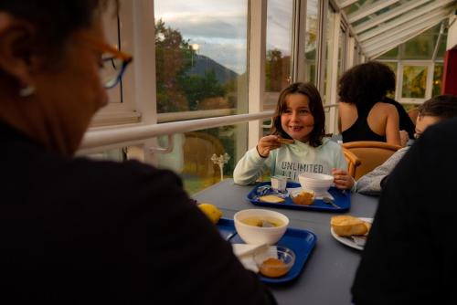 a little girl sitting at a table eating food at Village Vacances Cap France La Bolle in Saint Die