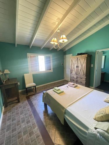 a bedroom with a large bed and a chair at Casitas El Lago in Carhué