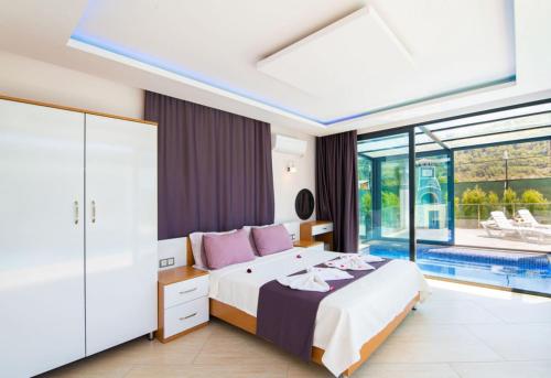 a bedroom with a bed and a swimming pool at Dreamy Villa with Private Pool and Jacuzzi in Kas in Sarıbelen