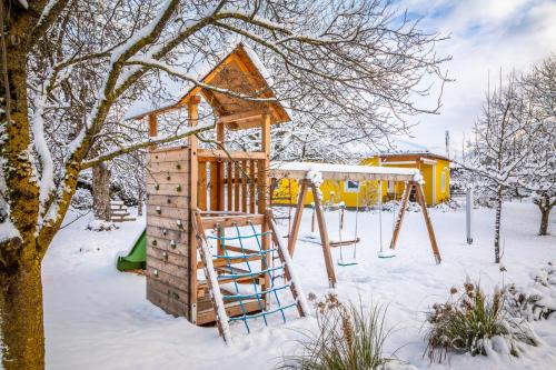 a playground in the snow with a slide at Ferienhaus Schlagerbauer Biohof in Salzburg