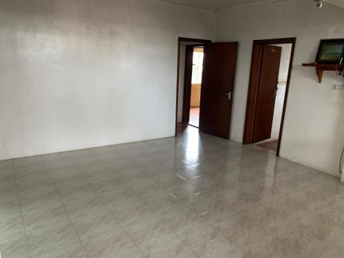 pusty pokój z dwoma drzwiami i podłogą wyłożoną kafelkami w obiekcie NR appartments w mieście Curepipe