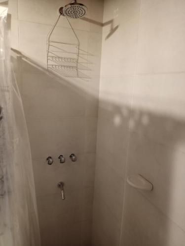 y baño con ducha y cortina de ducha. en cabaña la olivia en Lunlunta