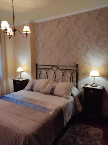 - une chambre avec un grand lit et 2 tables de chevet dans l'établissement Apartamento La Real, à Caldas de Reis