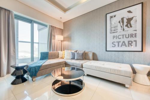 a living room with a bed and a couch at Maison Privee - Cool Dubai Apt next Burj Khalifa & Design District in Dubai
