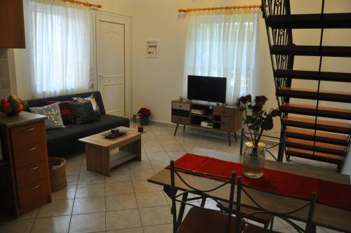 a living room with a couch and a tv at MagnoliaHouse 1 in Preveza