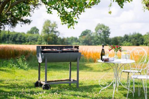 a barbecue grill with a table and a bottle of wine at Rose Cottage rural cosiness with footpaths to the local Macro Brewery Pub in Edwardstone
