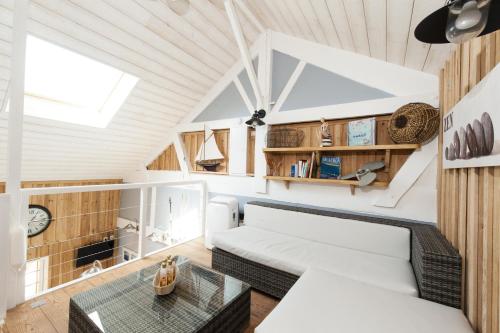 a living room with a white couch and a table at Les Gîtes De Noreda in Gujan-Mestras