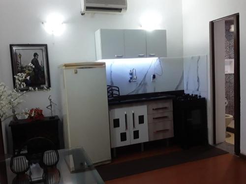  La cuisine est équipée de placards blancs et d'un réfrigérateur. dans l'établissement Chalé do Vale à 10 min de carro de Itacoatiara, à Niterói