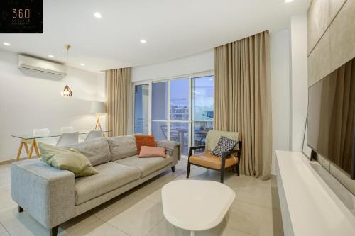 uma sala de estar com um sofá e uma mesa em Green Oasis: Home with Breathtaking View w/parking by 360 Estates em Sliema