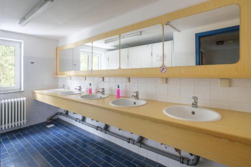a bathroom with three sinks and a mirror at Berggasthof Hörnerhaus in Bolsterlang