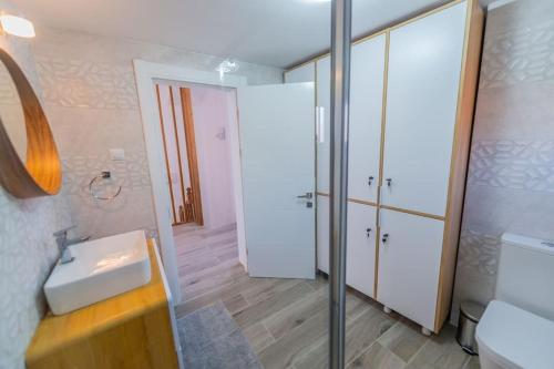 a bathroom with a sink and a toilet and a mirror at CasiAna Apartment in Râşnov