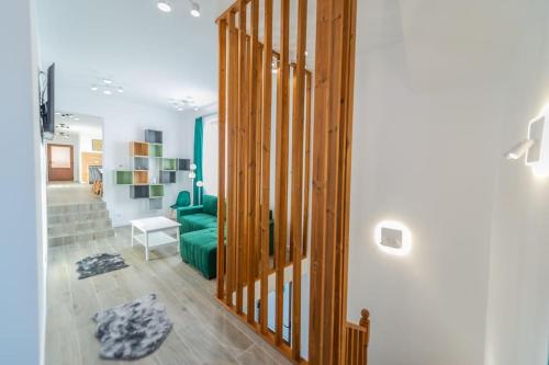 a living room with a green couch and a staircase at CasiAna Apartment in Râşnov