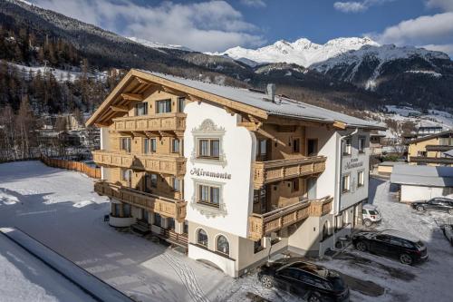 a building in the snow with mountains in the background at Miramonte in Sölden