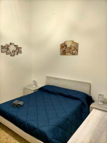 1 dormitorio con 1 cama con edredón azul en Casa Nonna Lucetta, en Campi Salentina