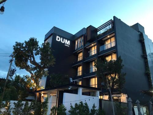 a black building with a dun sign on it at DUM Hotel - Si Phum in Chiang Mai
