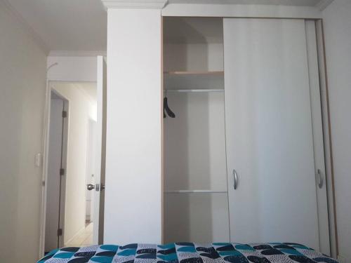 a bedroom with a bed and a closet and a mirror at Depto con internet y tv cable in Ovalle