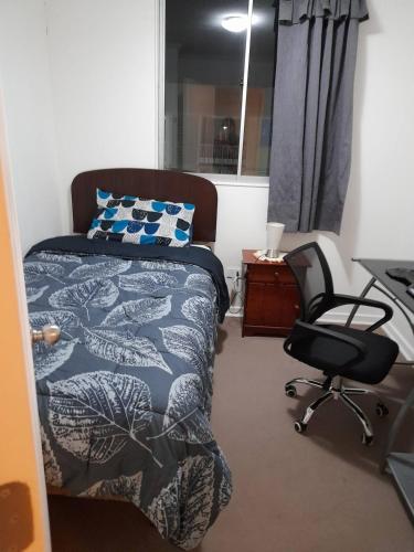 a bedroom with a bed and a desk and a chair at Depto con internet y tv cable in Ovalle