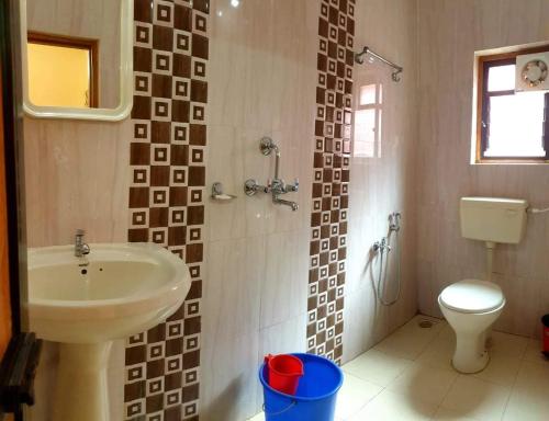 a bathroom with a sink and a toilet at Henry's Place in Calangute