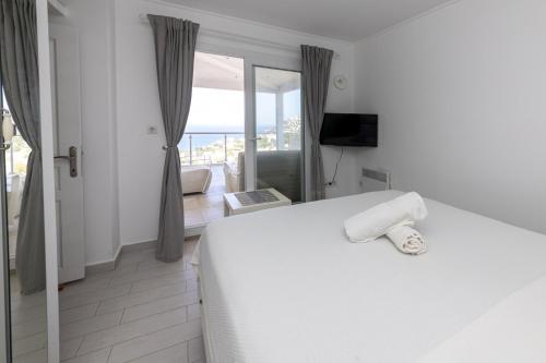 a bedroom with a white bed with a view of the ocean at Amazing Duplex House with Sea View in Bodrum in Gumusluk