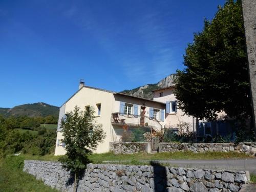 Cette grande maison blanche est dotée d'un mur en pierre. dans l'établissement Infocus-Du-Sud, à Soula