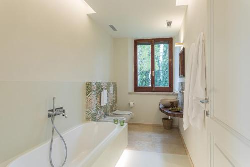 a white bathroom with a tub and a sink at VILLA ANNA ELISA 8, Emma Villas in Bevagna