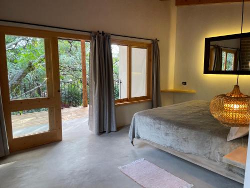 a bedroom with a bed and a sliding glass door at La Iguana Perdida in Santa Cruz La Laguna