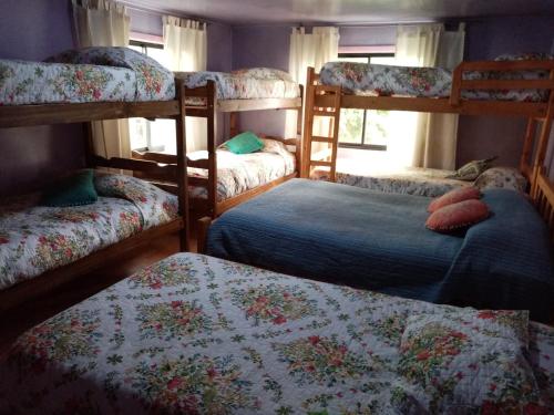 a bedroom with four bunk beds and a window at La Casa del Viento in Talcahuano