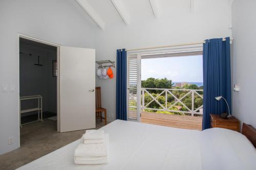 1 dormitorio con cama blanca y ventana grande en Piscadera Bay Resort 102 en Willemstad
