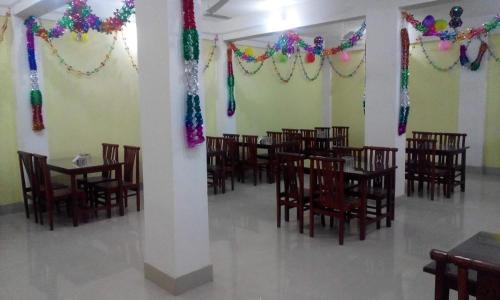 jadalnia ze stołami i krzesłami z kolorowymi dekoracjami w obiekcie BURGE GREEN-GUEST HOUSE & RESTAURANT w mieście Śrinagar