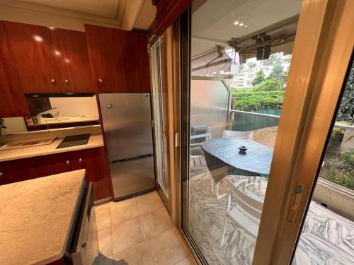 une cuisine avec une table et une porte coulissante en verre. dans l'établissement Superbe studio avec terrasse au cap d’antibes, à Antibes