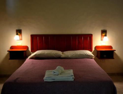 a bedroom with a bed with two lamps and towels on it at CABAÑAS TERRAZAS CHASCOMUS II in Chascomús
