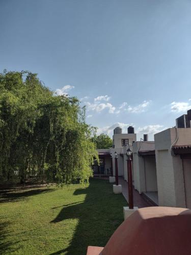 a view of a yard of a building with trees at CABAÑAS TERRAZAS CHASCOMUS II in Chascomús