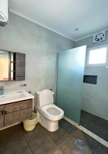 a bathroom with a toilet and a sink and a tub at بيات للنزل السياحية in Al Qarāḩīn
