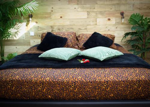 a bed with four pillows on it at Lasuite55 in Istres