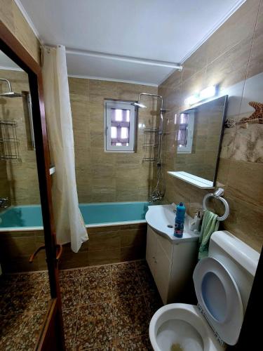 y baño con aseo, lavabo y bañera. en Apartament Bia, en Lupeni