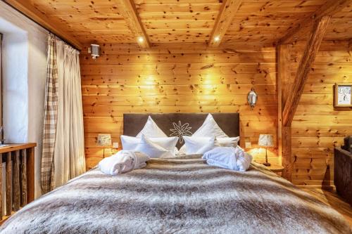 um quarto com uma cama grande num chalé de madeira em Chalet Hüttentraum em Inzell